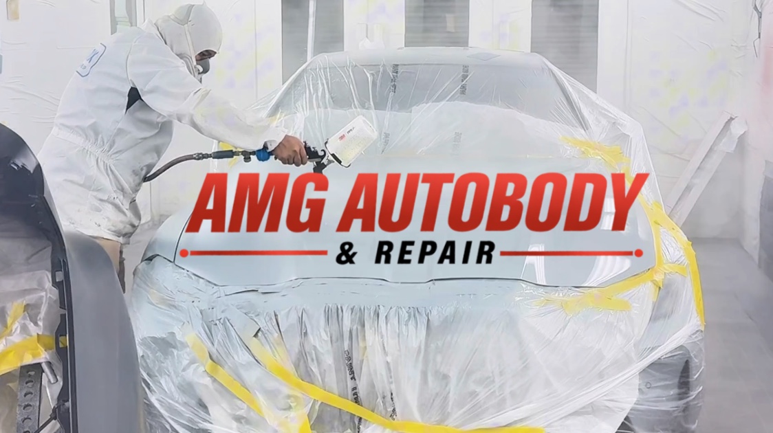 Painter spraying a car inside the AMG Autobody paint booth
